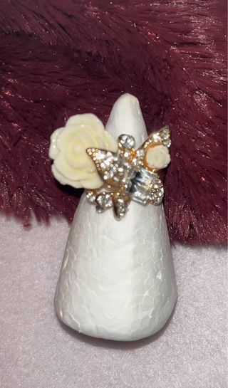 Anillo dorado con flor y pedrería