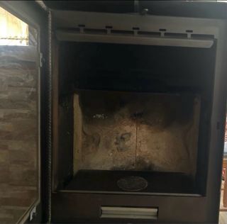 Chimenea de leña metálica con puerta de cristal