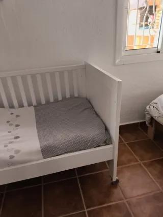 Cuna de bebé blanca con ruedas