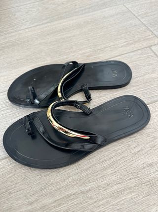 Sandalias planas negras con detalle dorado