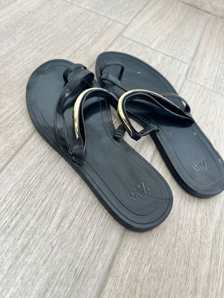 Sandalias planas negras con detalle dorado