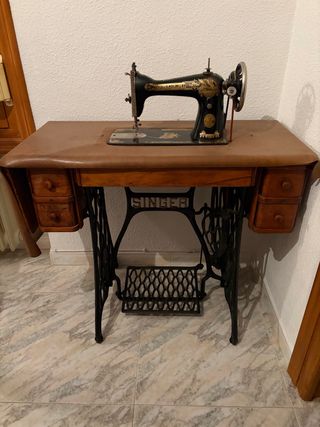 Máquina de coser Singer con mesa y funda.