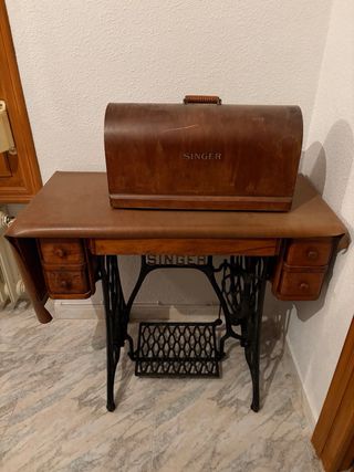 Máquina de coser Singer con mesa y funda.