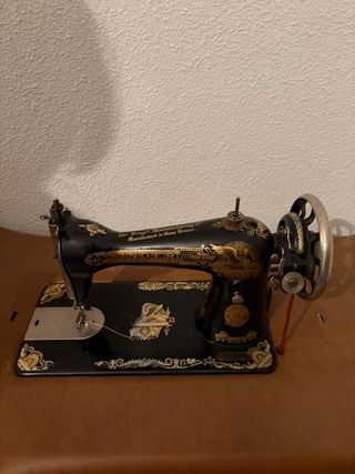 Máquina de coser Singer con mesa y funda.