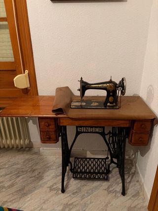 Máquina de coser Singer con mesa y funda.