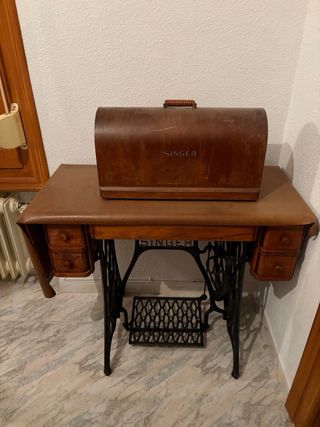 Máquina de coser Singer con mesa y funda.