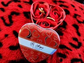 Anillos de oro en caja de corazón con rosas
