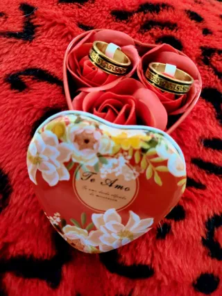 Anillos de oro en caja de corazón con rosas