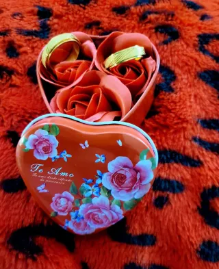 Anillos de oro en caja de corazón con rosas