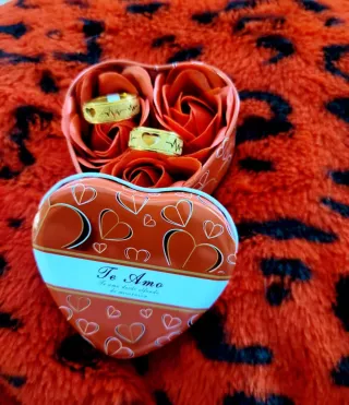 Anillos de oro en caja de corazón con rosas
