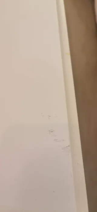 Mesa de centro blanca con tapa de cristal y cajón.