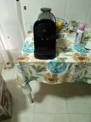 Cafetera de cápsulas negra con capsulas de regalo