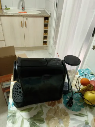 Cafetera de cápsulas negra con capsulas de regalo