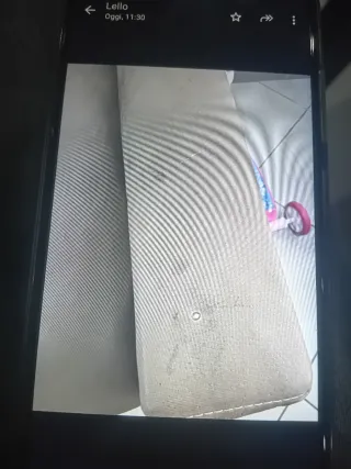 Divano tessuto beige/marrone con un piccolo segno