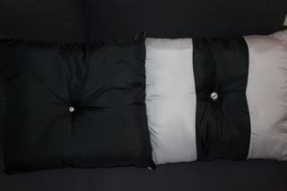 Almofadas pretas e cinzentas em cetim