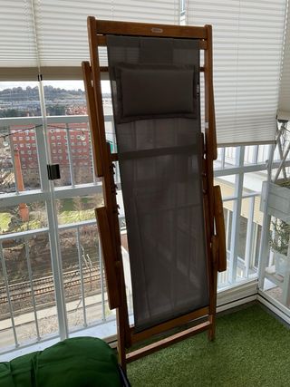 Tumbona de madera con cojín azul y blanco