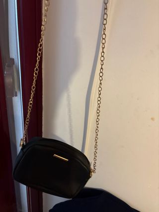 Bolso negro y dorado con cadena