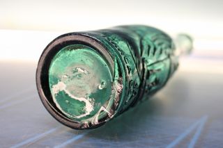 Botella antigua El Águila, verde, con relieve.