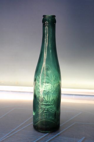 Botella antigua El Águila, verde, con relieve.