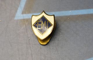Pin, insignia EMI, Escuela Mandos Intermedios o una marca de electrodomésticos.