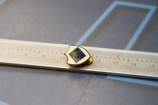 Pin, insignia EMI, Escuela Mandos Intermedios o una marca de electrodomésticos.