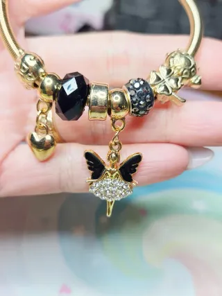 Pulsera dorada con dijes de bailarina y corazón