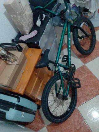 Bicicleta BMX verde pero tiene  una rueda rota