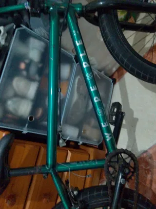 Bicicleta BMX verde pero tiene  una rueda rota
