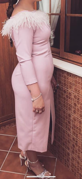 Vestido rosa elegante con plumas.