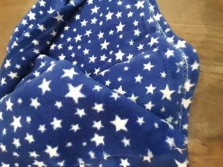 Manta de sofá azul con estrellas blancas