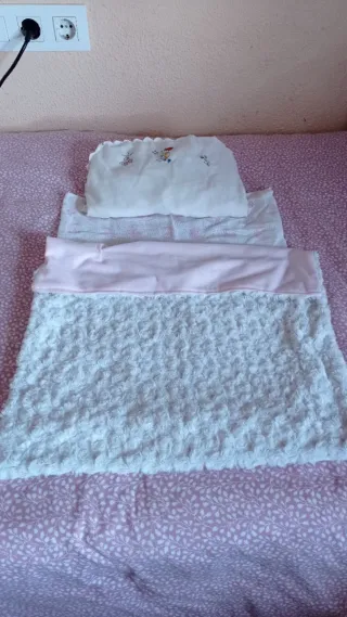 Cuna de juguete rosa con estrellas y accesorios.