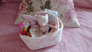 Cuna de juguete rosa con estrellas y accesorios.