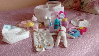 Cuna de juguete rosa con estrellas y accesorios.