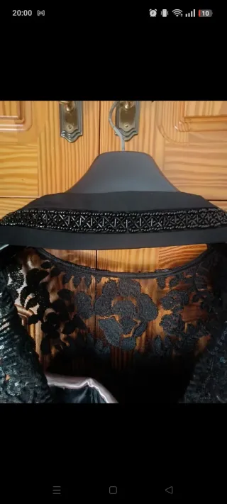 Mono de encaje negro con cinturón ajustado.