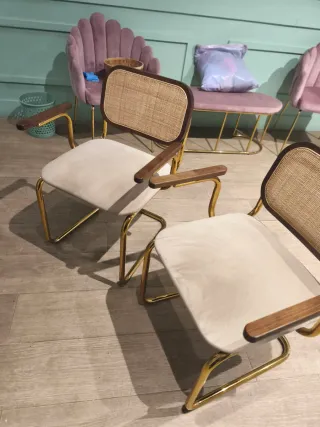 Dos sillones de diseño beige y dorado