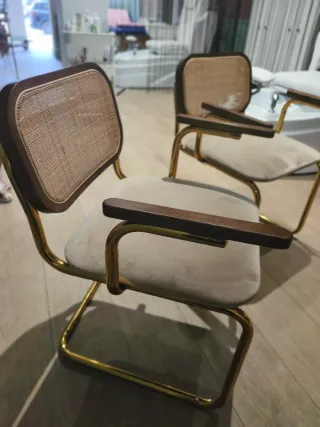 Dos sillones de diseño beige y dorado