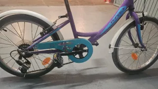 Bicicleta niña morada, tiene cesta blanca.