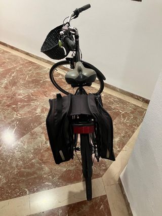 Bicicleta BTWIN negra con cesta y alforja