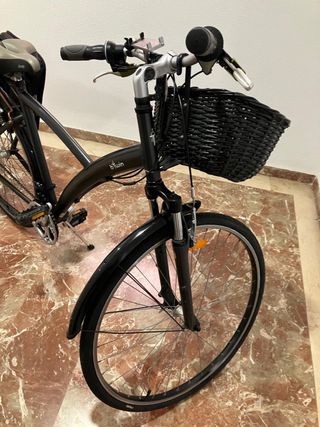 Bicicleta BTWIN negra con cesta y alforja