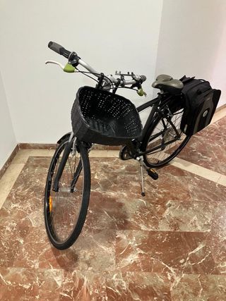 Bicicleta BTWIN negra con cesta y alforja
