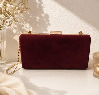 Bolso de mano color tinto con detalles dorados