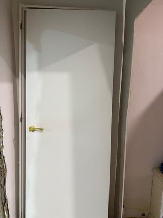 Puerta blanca con manilla dorada