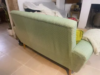 Sofá verde de tela con patas de madera