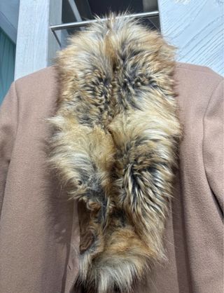 Cappotto beige con collo e polsini in pelliccia.