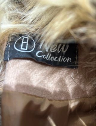 Cappotto beige con collo e polsini in pelliccia.