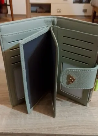 Cartera de mano verde con detalles dorados