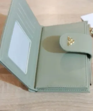 Cartera de mano verde con detalles dorados