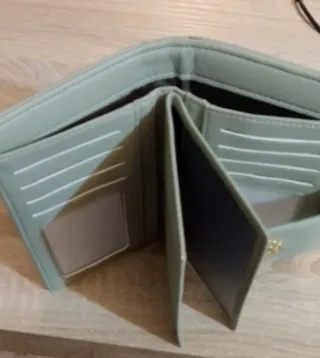 Cartera de mano verde con detalles dorados