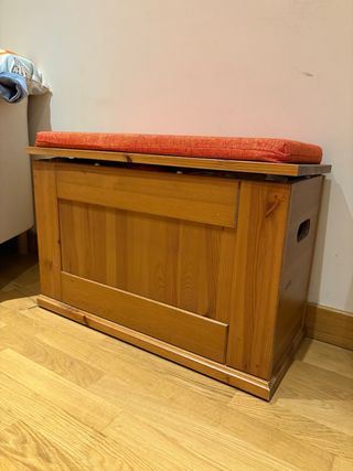 Baúl de madera con cojín naranja