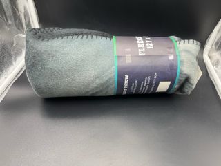 Manta polar gris y negra con etiqueta